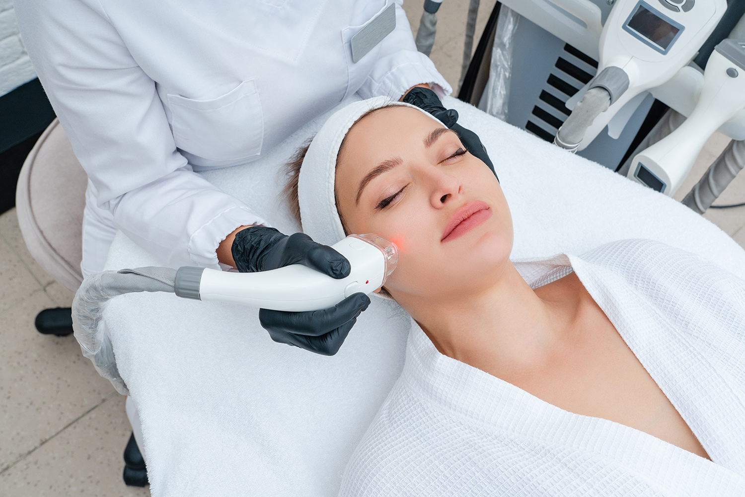 Young woman receiving laser treatment in cosmetology clinic