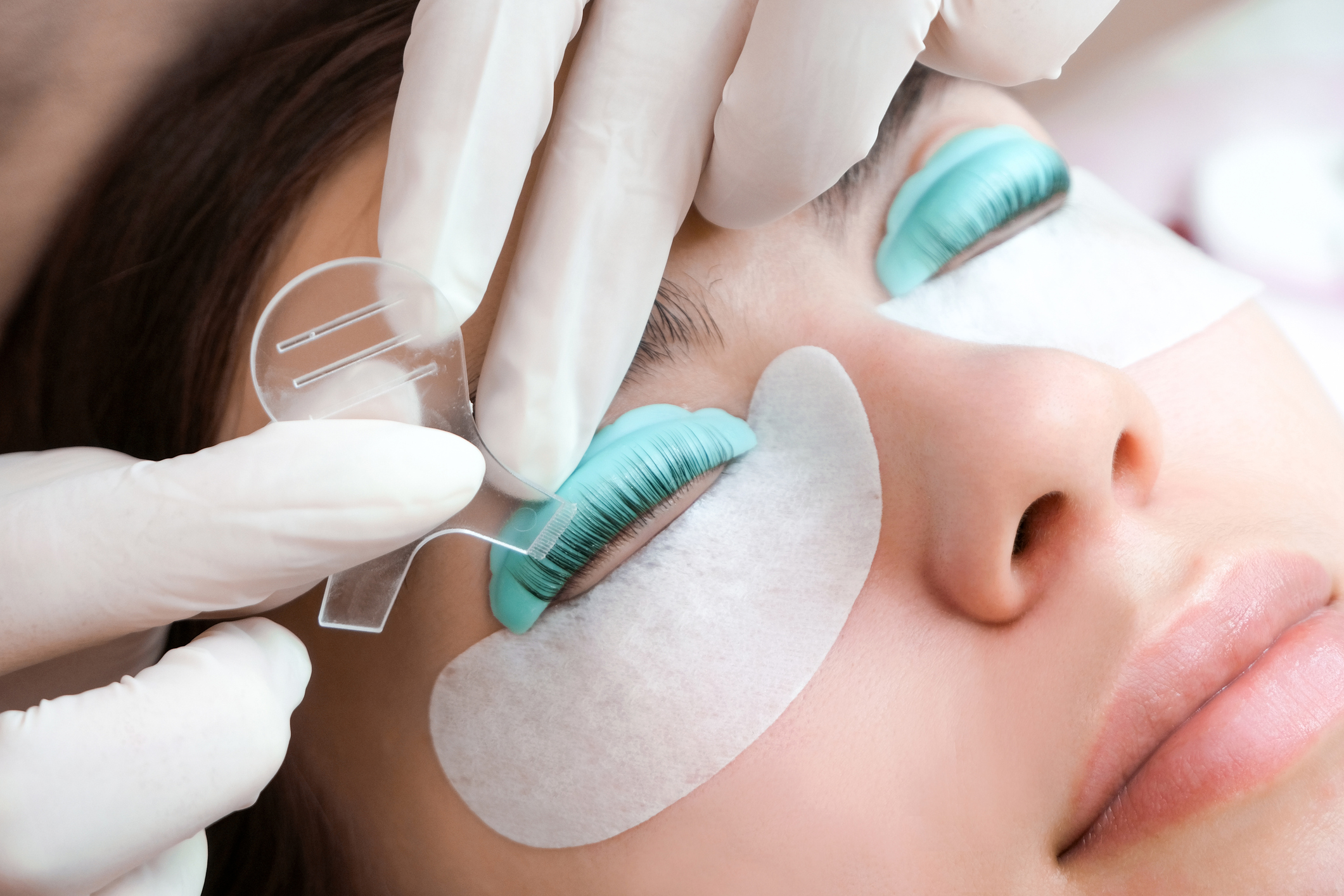 Young woman doing eyelash lamination procedure in a beauty salon