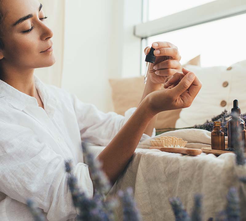 Young woman applying natural organic essential oil