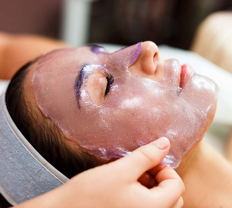 beautician applies a transparent jelly peer mask