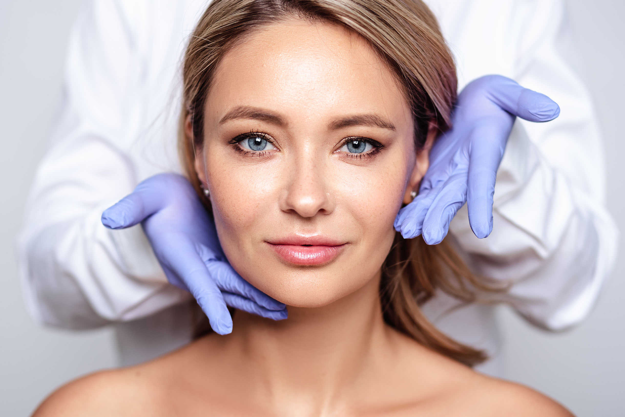 blonde woman with cosmetologyst hands in a gloves, preparation for operation or procedure